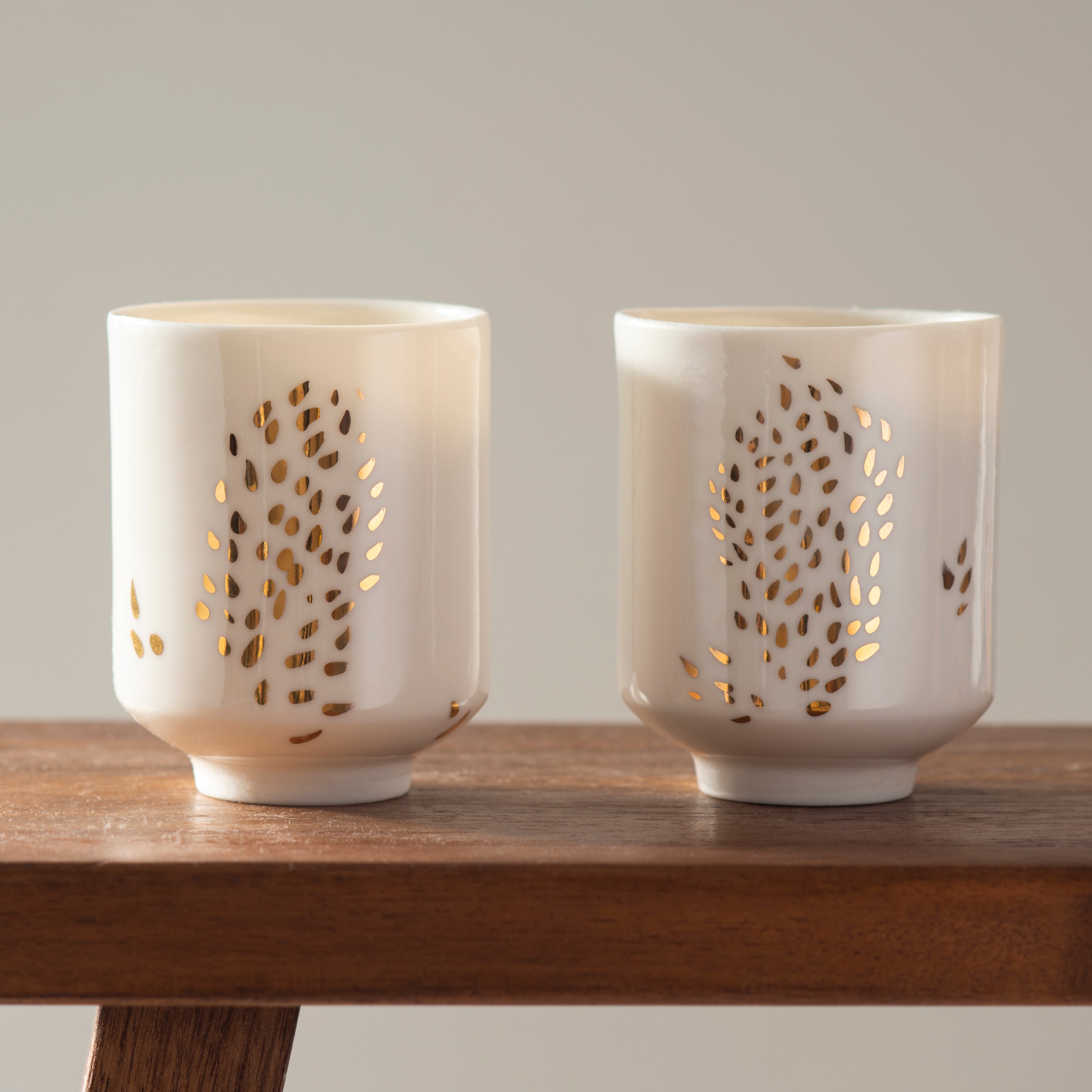 Two tea cups made out of transclucent porcelain decorated with gold 